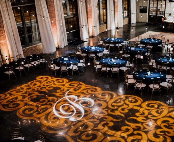 a room full of tables and chairs for wedding reception